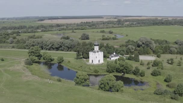 Rusia, Bogolyubovo. Vista aérea de la Iglesia de la Intercesión en el Nerl. Iglesia ortodoxa y símbolo de la Rusia medieval. 4K — Vídeo de stock