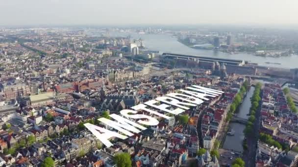 Amsterdam, Niederlande. Fliegen über die Dächer der Stadt in Richtung Amsterdam Central Station (Amsterdam Centraal) und rund um die Oudekerk Kirche (De Oude Kerk). 4K — Stockvideo