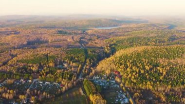 Köy. Günbatımında karışık ormanın üzerinde uçmak. Yekaterinburg çevresi. Ural, Rusya. 4K