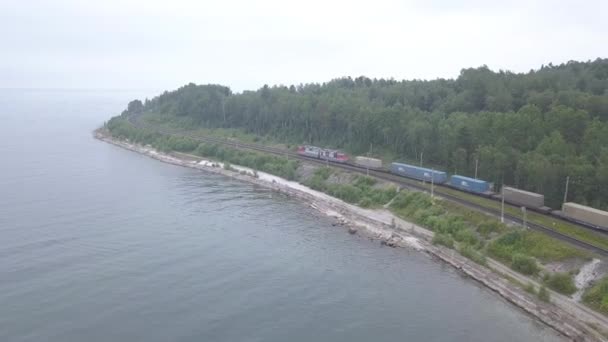 Ryssland, Baikal. Transsibiriska järnvägen, Bajkalsjökusten. Tåg rörelse längs sjön stranden. 4K — Stockvideo