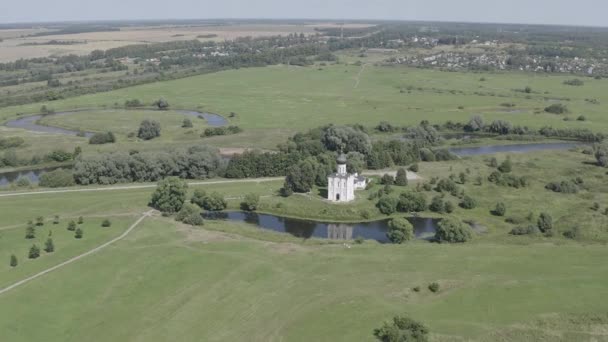 Rusia, Bogolyubovo. Vista aérea de la Iglesia de la Intercesión en el Nerl. Iglesia ortodoxa y símbolo de la Rusia medieval. 4K — Vídeos de Stock