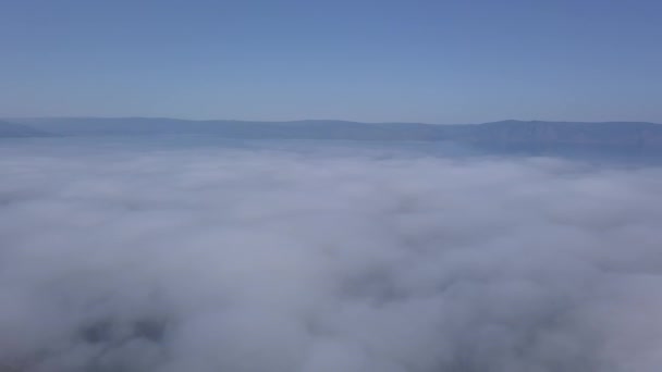 Voando acima das nuvens. Costa do Lago Baikal. Montanhas cobertas de floresta. A Rússia. 4K — Vídeo de Stock