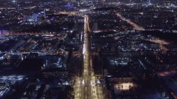 Ekaterinburg, Rusya. Aydınlatılmış bir caddenin üzerinde uçuyor. Şehir merkezi uzaktan görülebilir. 4K — Stok video
