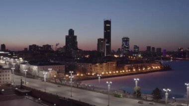 Ekaterinburg, Rusya. Baharın başında gece şehri. Baraj, gökdelenlerin siluetleri. 4K