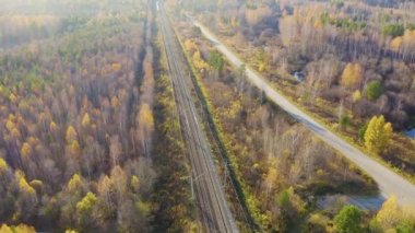 Rusya, Ural, Yekaterinburg. Vagonlu tren. Elektrikli demiryolu. Otoyol. Gün batımı ışığı. 4K