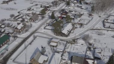 Kışın uçmak. Karların altında eski evleri olan bir köy. - Rusya. 4K