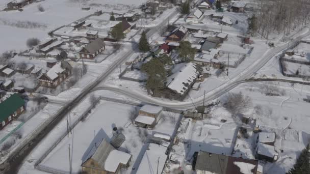 Vliegen in de winter. Dorp met oude huizen onder de sneeuw. Rusland. 4K — Stockvideo
