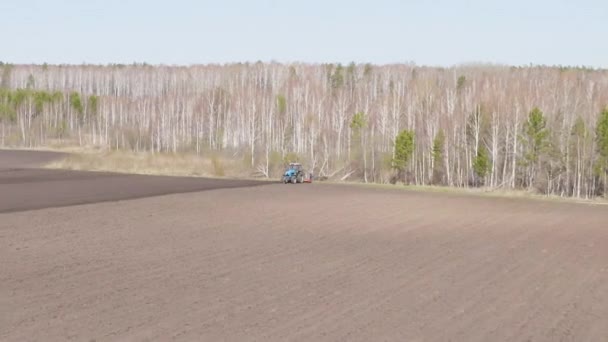 Dolly zoom. Rusya, Urallar. Patatesleri tarlada bir traktör ve bir kombinasyon ile ekiyorlar. Bahar — Stok video