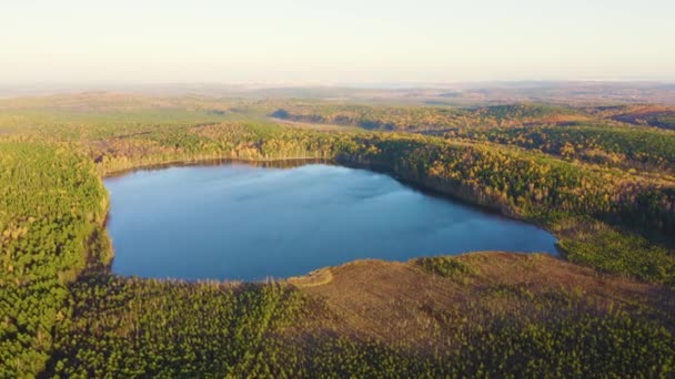 Ekaterinburg, Rusia. Lacul Peschanoye (Sandy) este dreptunghiular în formă înconjurat de pădure în toamnă. Apus de soare. 4K — Videoclip de stoc