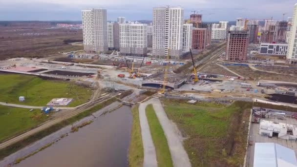 Ekaterinburg, Rússia. A construção de uma ponte sobre o rio. Nova Área de Construção - Akademicheskiy (Acadêmico). 4K — Vídeo de Stock