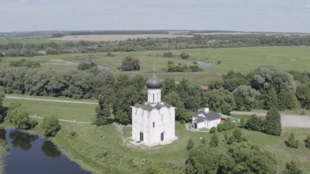 Russia, Bogolyubovo. Aerial view of Church of the Intercession on the Nerl. Orthodox church and a symbol of medieval Russia. 4K — Stock Footage Russia, Bogolyubovo. Aerial view of Church of the Intercession on the Nerl. Orthodox church and a symbol of medieval Russia. 4K Royalty Free Stock Video