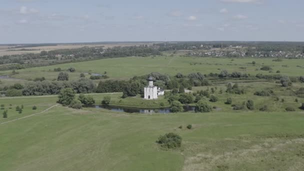 Russia, Bogolyubovo. Aerial view of Church of the Intercession on the Nerl. Orthodox church and a symbol of medieval Russia. 4K — Stock Footage Russia, Bogolyubovo. Aerial view of Church of the Intercession on the Nerl. Orthodox church and a symbol of medieval Russia. 4K Royalty Free Stock Video