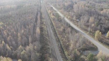 Rusya, Ural, Yekaterinburg. Vagonlu tren. Elektrikli demiryolu. Otoyol. Gün batımı ışığı. 4K