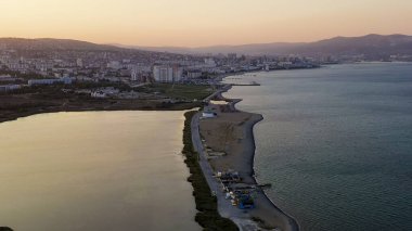 Novorossiysk, Rusya. Gün batımında şehrin manzarası. Şehir seti. Karadeniz 'deki Tsemesskaya Körfezi, Hava Görüntüsü  