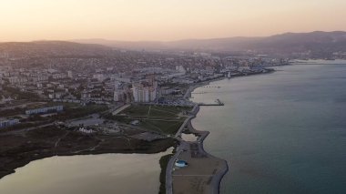 Novorossiysk, Rusya. Gün batımında şehrin manzarası. Şehir seti. Karadeniz 'deki Tsemesskaya Körfezi, Hava Görüntüsü  