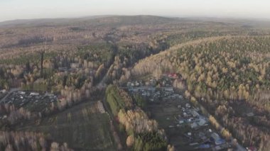 Köy. Günbatımında karışık ormanın üzerinde uçmak. Yekaterinburg çevresi. Ural, Rusya. 4K