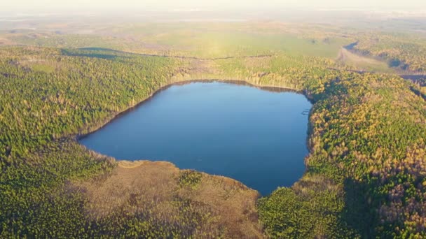 Yekaterinburg, Russia. Lake Peschanoye (Sandy) is rectangular in shape surrounded by forest in the fall. Sunset time. 4K — Stock Video