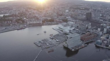 Oslo, Norveç. Gün batımında şehir manzarası. Arka ışık. Şehrin merkezi kısmından. Oslo Opera Binası. Opera Oslo. 4K