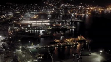Novorossiysk, Rusya. Geceleyin Novorossiysk Limanı. Gece şehir ışıkları. Karadeniz 'deki Tsemesskaya Körfezi. 4K