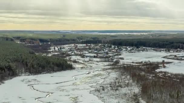 Dolly zoom. Dolly Zoom. Der Flug über einen mit Schnee bedeckten Sumpf mit einem dunklen Streifen des Flusses. Das Dorf im Hintergrund. Die Lichter einer Sonne — Stockvideo