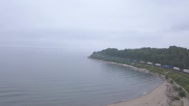 Rusland, Baikal. Trans-Siberische spoorweg, kust van het Baikalmeer. Treinverkeer langs de oever van het meer. 4K — Stockvideo