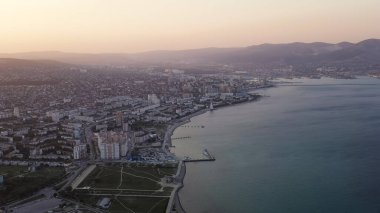 Novorossiysk, Rusya. Gün batımında şehrin manzarası. Şehir seti. Karadeniz 'deki Tsemesskaya Körfezi, Hava Görüntüsü  