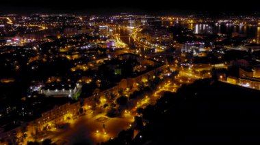 Astrakhan, Rusya. Geceleri Astrakhan şehrinin manzarası. Volga 'nın durgun sularının seti. Lenin Meydanı. 4K