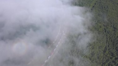 Bulutların üzerinde uçuyor. Baykal Gölü kıyısında. Ormanla kaplı dağlar. - Rusya. 4K