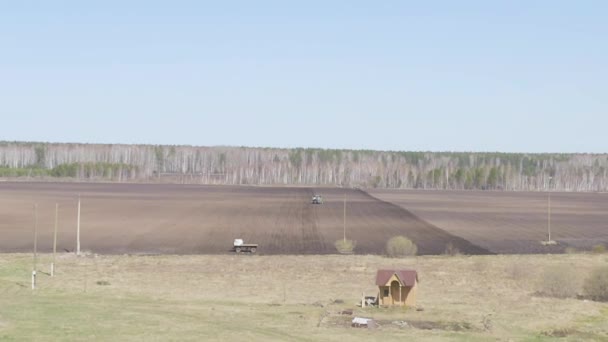 Dolly zoom. Rusia, los Urales. Plantar patatas en el campo con una cosechadora y un tractor. Primavera — Vídeos de Stock