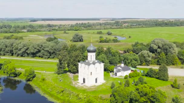 Rusia, Bogolyubovo. Vista aérea de la Iglesia de la Intercesión en el Nerl. Iglesia ortodoxa y símbolo de la Rusia medieval. 4K — Vídeos de Stock