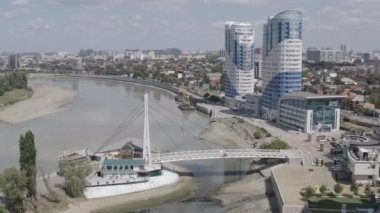 Krasnodar, Rusya, Öpücükler Köprüsü. Kubanskaya seti üzerinde yeni yerleşim yerleri. Kuban Nehri. Yazın şehir üzerinde uçuyorum. 4K