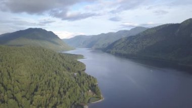 Teletskoye Gölü 'nün panoramik manzarası bulutlara tırmanıyor. Rusya, Altai. Ormanlarla kaplı dağlar. 4K