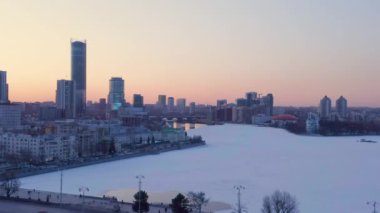 Ekaterinburg, Rusya. Şehir merkezi, ev siluetleri. Gün batımından sonra şehir göleti. Baharın başında. Gün batımı zamanı. 4K