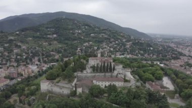 Brescia, İtalya. Castello di Brescia. Bulutlu havada şehrin üzerinde uçmak. 4K