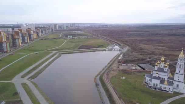 Ekaterinburg, Rússia. Um lago com uma barragem num parque novo. Nova Área de Construção - Akademicheskiy (Acadêmico). 4K — Vídeo de Stock