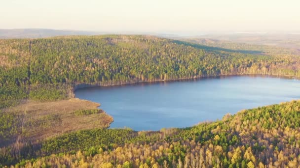 Dolly zoomen. Yekaterinburg, Rusland. Lake Peschanoye (Sandy) is rechthoekig van vorm, omgeven door bos in de herfst. Zonsondergang — Stockvideo