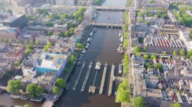 Amsterdam, Hollanda. Şehrin çatılarında uçuyor. Amstel Nehri, Amstel Geçidi. 4K