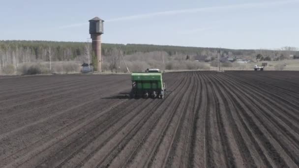Oroszország, az Urál. Burgonyát ültetek a mezőn kombájnnal és traktorral. Tavasz. 4K — Stock videók