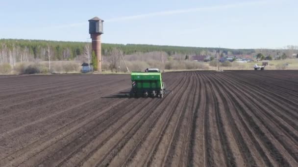 Rusya, Urallar. Patatesleri tarlada bir traktör ve bir kombinasyon ile ekiyorlar. Bahar. 4K — Stok video