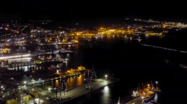 Novorossiysk, Rusya. Geceleyin Novorossiysk Limanı. Gece şehir ışıkları. Karadeniz 'deki Tsemesskaya Körfezi. 4K