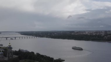Kostroma, Rusya. Kostroma şehrinin tarihi merkezi üzerinde uçuş. Yolcu gemisi Volga nehrinde yelken açıyor, Gökkuşağı. 4K