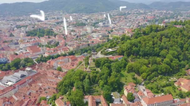 Graz, Österrike. Klocktornet i Graz. Den historiska stadskärnan flygfoto. Schlossberg (Slottskullen). 4K — Stockvideo