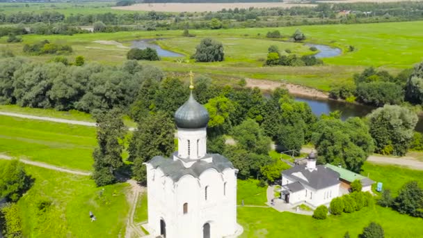 Rusia, Bogolyubovo. Vista aérea de la Iglesia de la Intercesión en el Nerl. Iglesia ortodoxa y símbolo de la Rusia medieval. 4K — Vídeo de stock