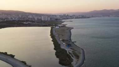 Novorossiysk, Rusya. Gün batımında şehrin manzarası. Şehir seti. Karadeniz 'deki Tsemesskaya Körfezi. 4K