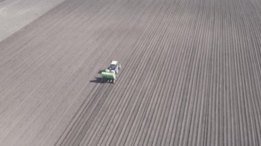 Rusya, Urallar. Patatesleri tarlada bir traktör ve bir kombinasyon ile ekiyorlar. Bahar. 4K