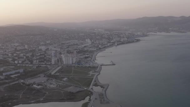Novorossijsk, Ryssland. Panorama över staden under solnedgången. Stadsbanken. Tsemesskaja Bay i Svarta havet. 4K — Stockvideo