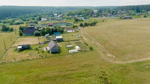 Russia, Ural. Flying over the fields. Village houses, Aerial View