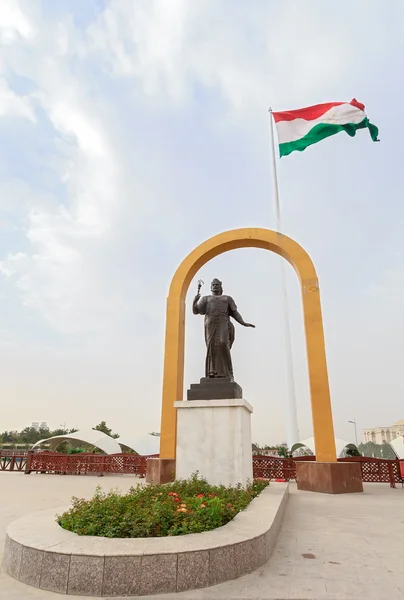 Somoni statue in front of the flag of Tajikistan. Dushanbe — Stock Photo, Image