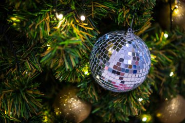 Altın parıltı, cam top ve altın top Noel ağacında seçici odak altında ve bazı bölgelerde bulanık.