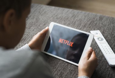 Boy using tablet pc to watch netflix online